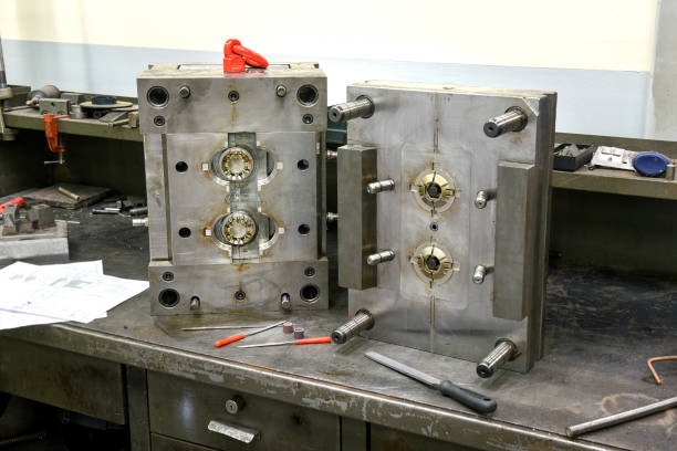 Open in half metal mold and tools close-up on workbench in the workshop